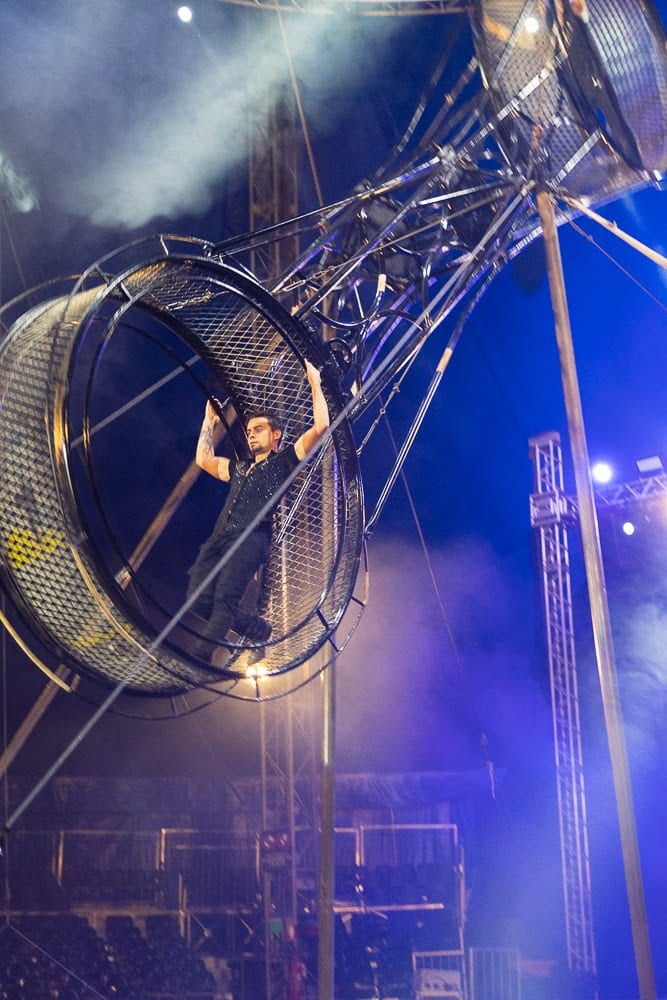 Rodrigo Gomez inside the wheel amid stage smoke, Le Cirque Amar.
