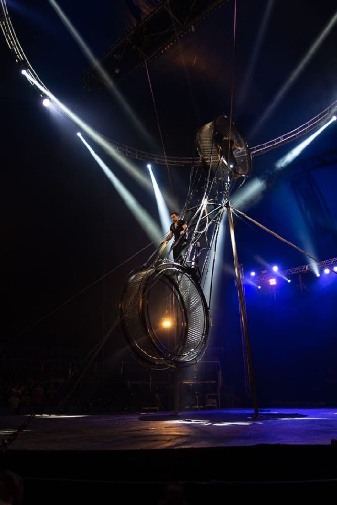 The wheel silhouetted under crossing followspots, Le Cirque Amar.
