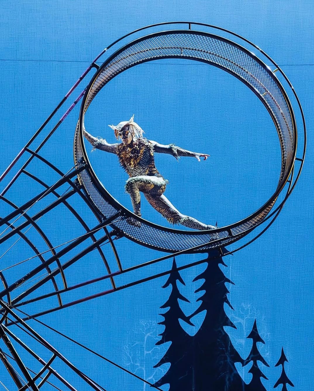 Rodrigo Gomez inside the wheel on an outdoor rig against the sky.